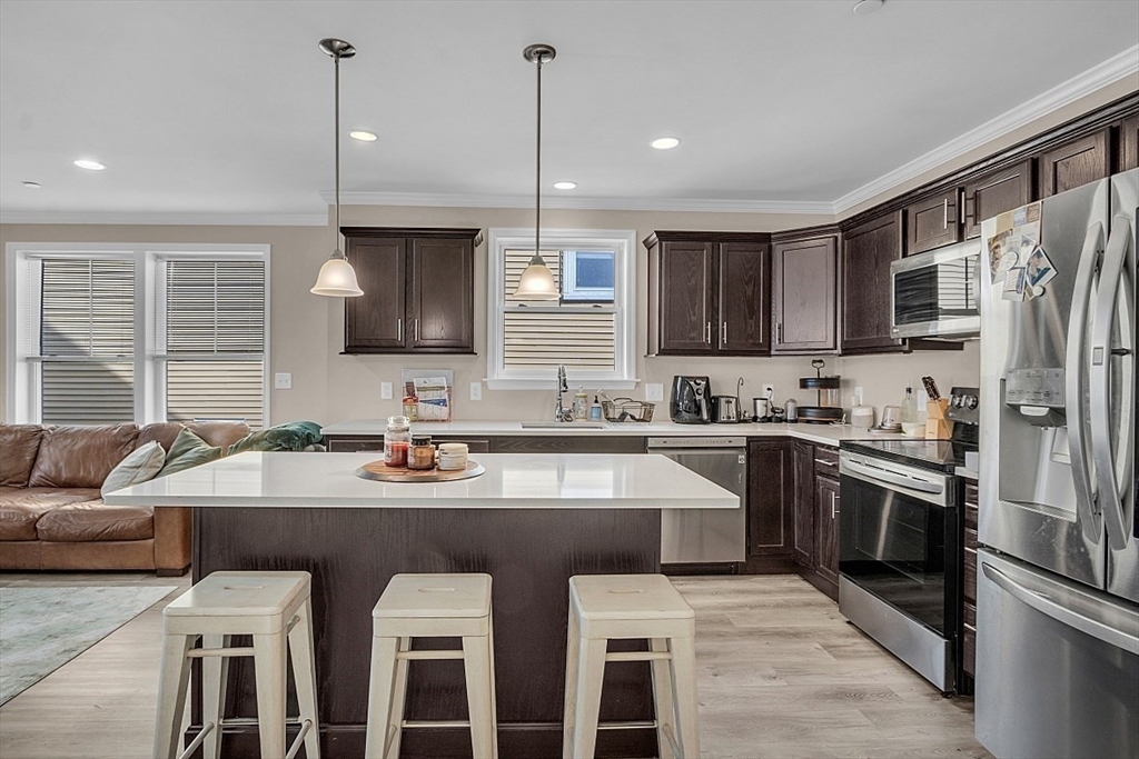 3 Elm Street, Unit 4 Boston, MA 02122 - Photo 8 of 24 a kitchen with stainless steel appliances granite countertop a sink stove and refrigerator
