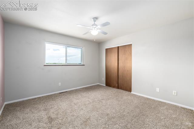 6065 Mulberry Road Calhan, CO 80808 - Photo 17 of 45 Unfurnished bedroom with carpet floors, a closet, and ceiling fan