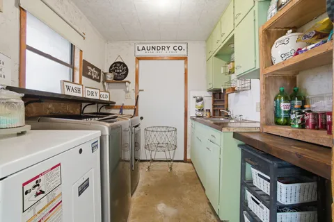 a utility room with cabinets washer and dryer