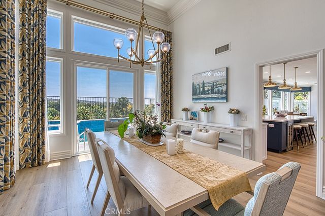 a view of a dining room with furniture a chandelier and wooden floor