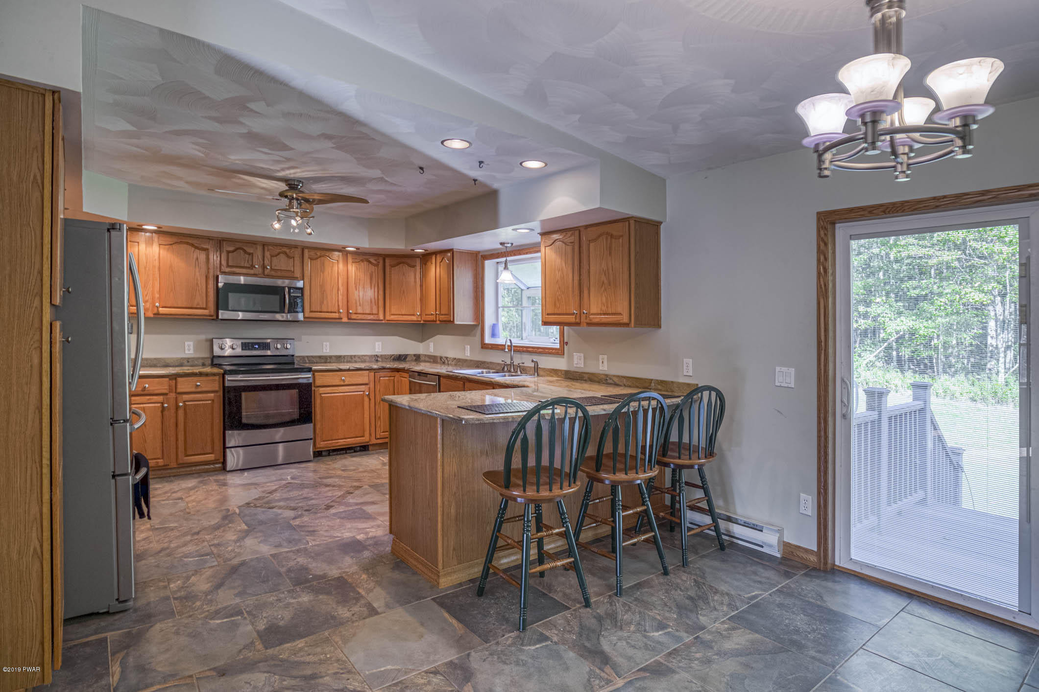 424 Old Gravity Road Lake Ariel, PA 18436 - Photo 6 of 46 a kitchen with stainless steel appliances granite countertop a stove top oven a sink dishwasher a dining table and chairs with wooden floor