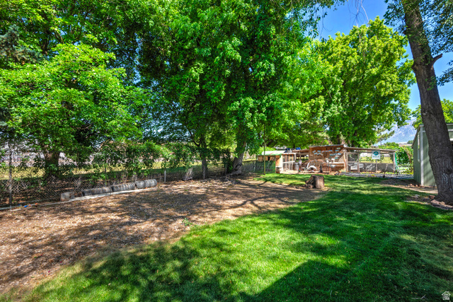 178 17th Street Ogden, UT 84404 - Photo 4 of 29 Expansive backyard featuring a manicured lawn, established trees, and a dedicated mulch area