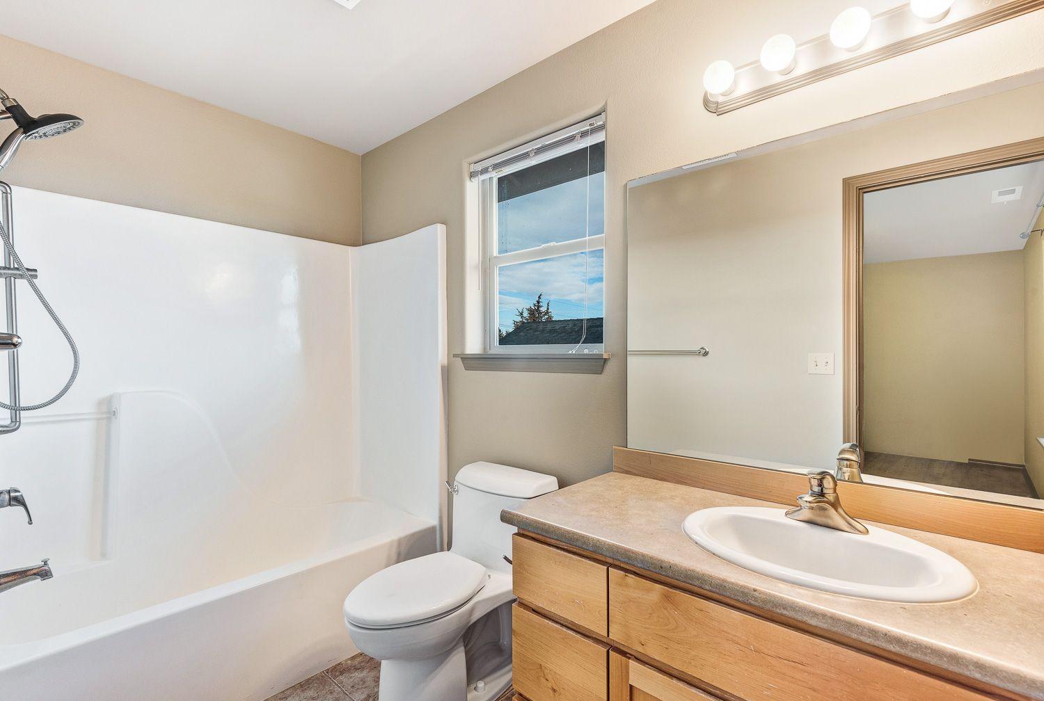 63335 Vogt Road Bend, OR 97701 - Photo 14 of 20 a bathroom with a granite countertop sink a toilet and a mirror