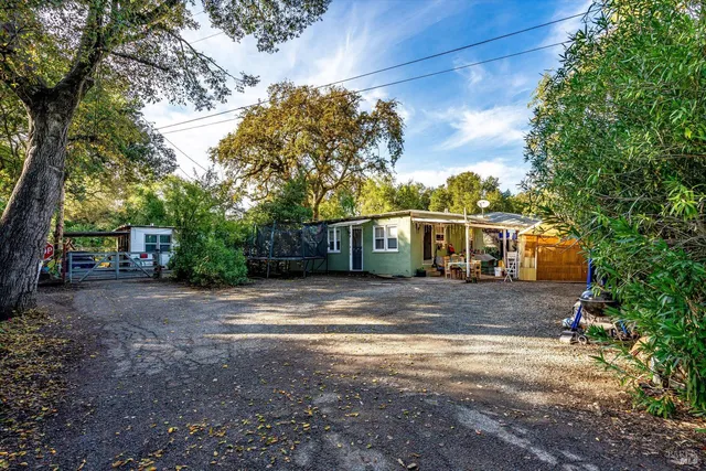 a front view of a house with a yard and trees