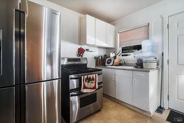 a kitchen with stainless steel appliances and refrigerator