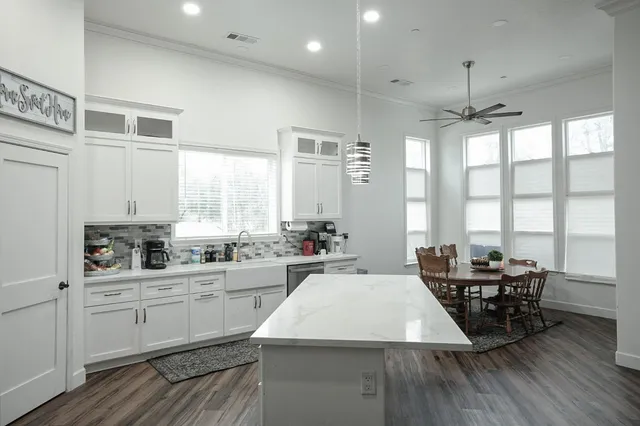 a large kitchen with sink cabinets and wooden floor