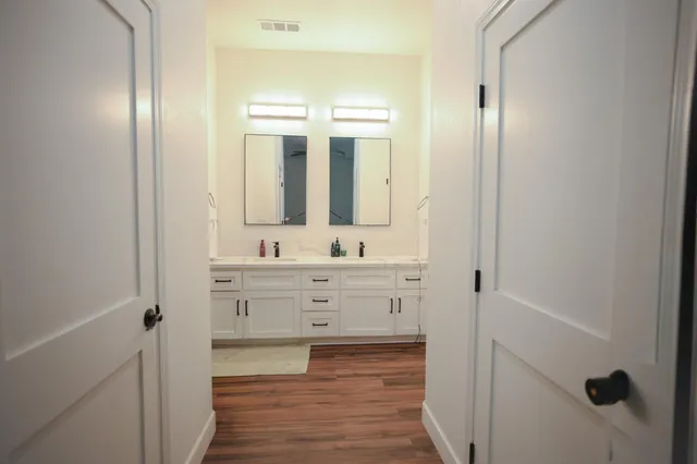 a bathroom with a double vanity sink and mirror