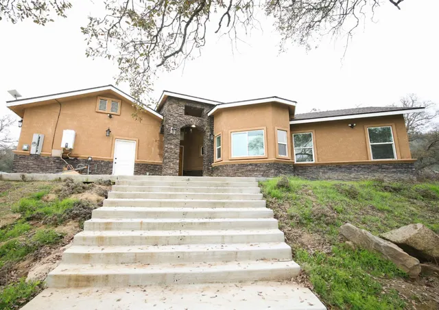 a front view of a house with a garden and yard
