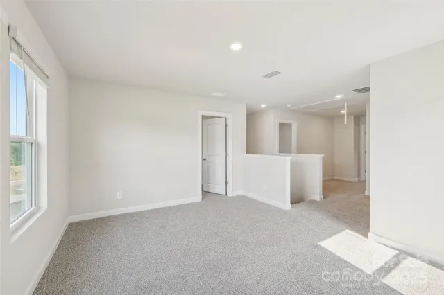 a view of a big room with windows and chandelier