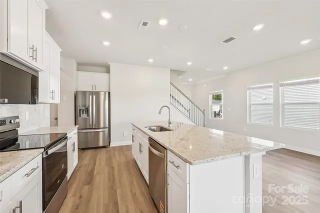 a kitchen with a sink a counter top space stainless steel appliances and cabinets