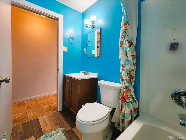 a white toilet sitting next to a bathroom sink and a mirror