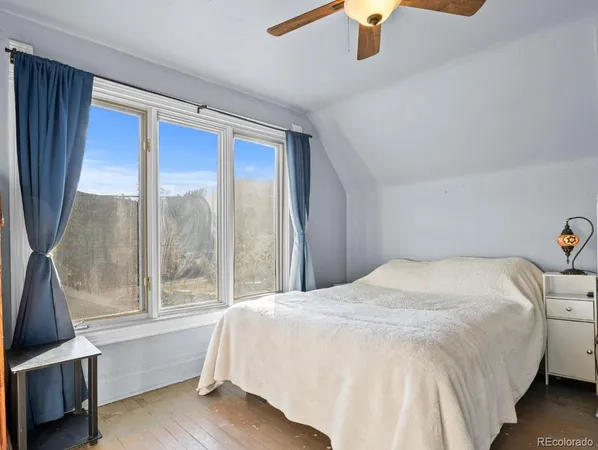 a bedroom with a bed and a large window