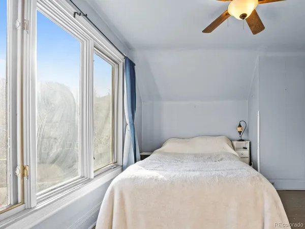 a bedroom with a bed and a large window