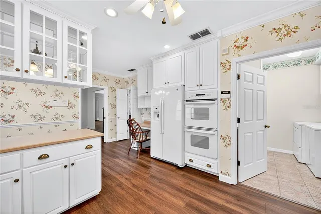 a kitchen with stainless steel appliances white cabinets and wooden floors