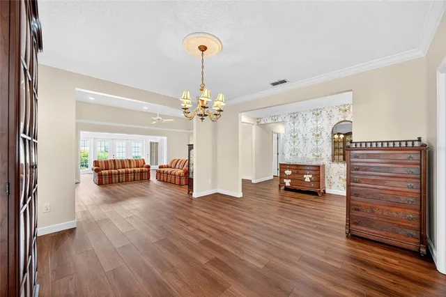 a view of a livingroom with furniture wooden floor chandelier and a window