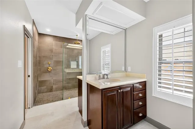 a bathroom with a granite countertop sink a shower and a mirror