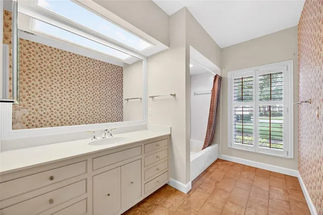 a spacious bathroom with a double vanity sink a mirror and a shower