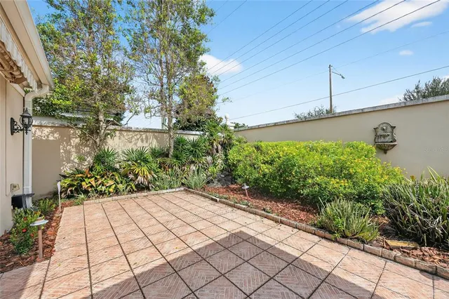a view of house in front of a big yard with large trees
