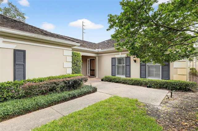 a front view of a house with a yard and potted plants