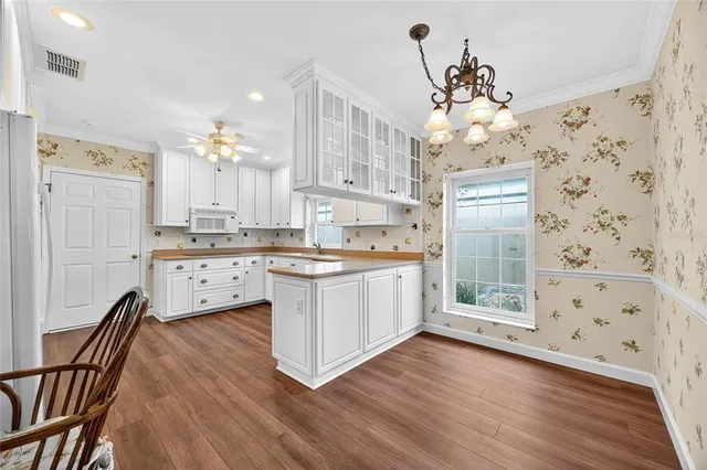 a kitchen with granite countertop a refrigerator a sink a stove and wooden floors