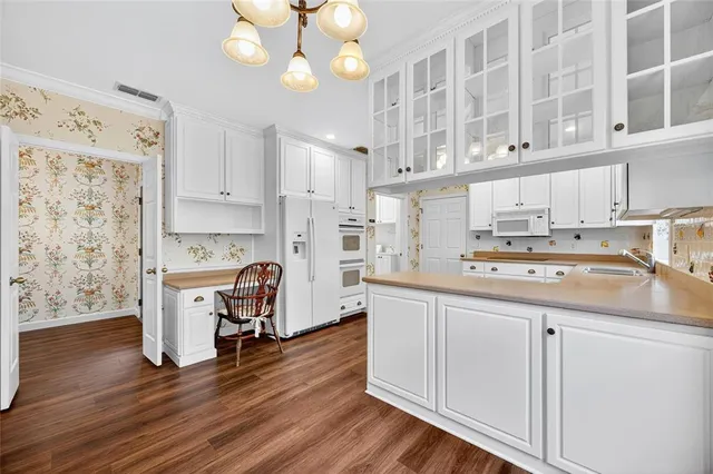 a kitchen with a sink cabinets and wooden floor
