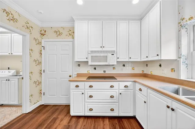 a kitchen with stainless steel appliances a stove and white cabinets