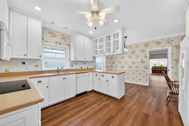 a large white kitchen with cabinets