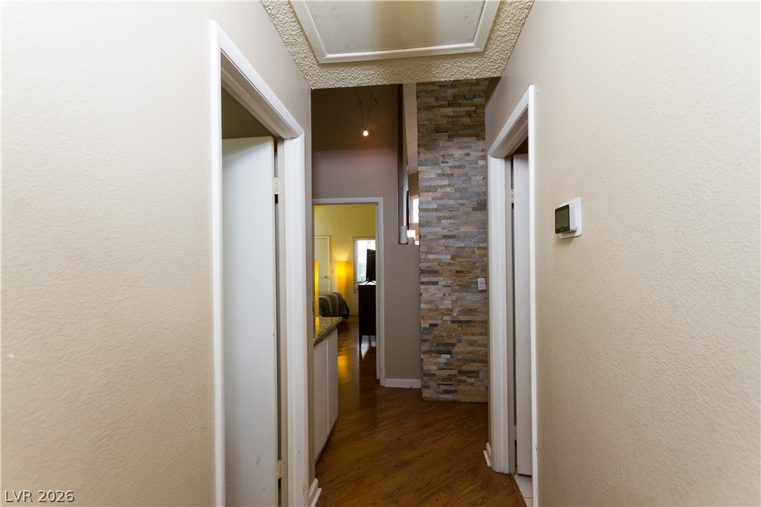 133 Coventry Circle Henderson, NV 89074 - Photo 53 of 99 Hallway from garage. Bedroom 2 to left. Bathroom to right. Primary bedroom at far end.