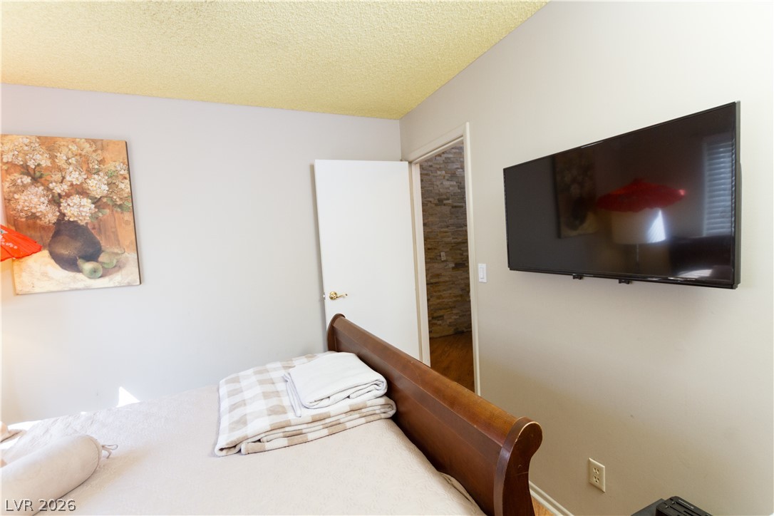 133 Coventry Circle Henderson, NV 89074 - Photo 10 of 99 Bedroom 2. Exit to hallway. Back of fireplace visible in hallway.