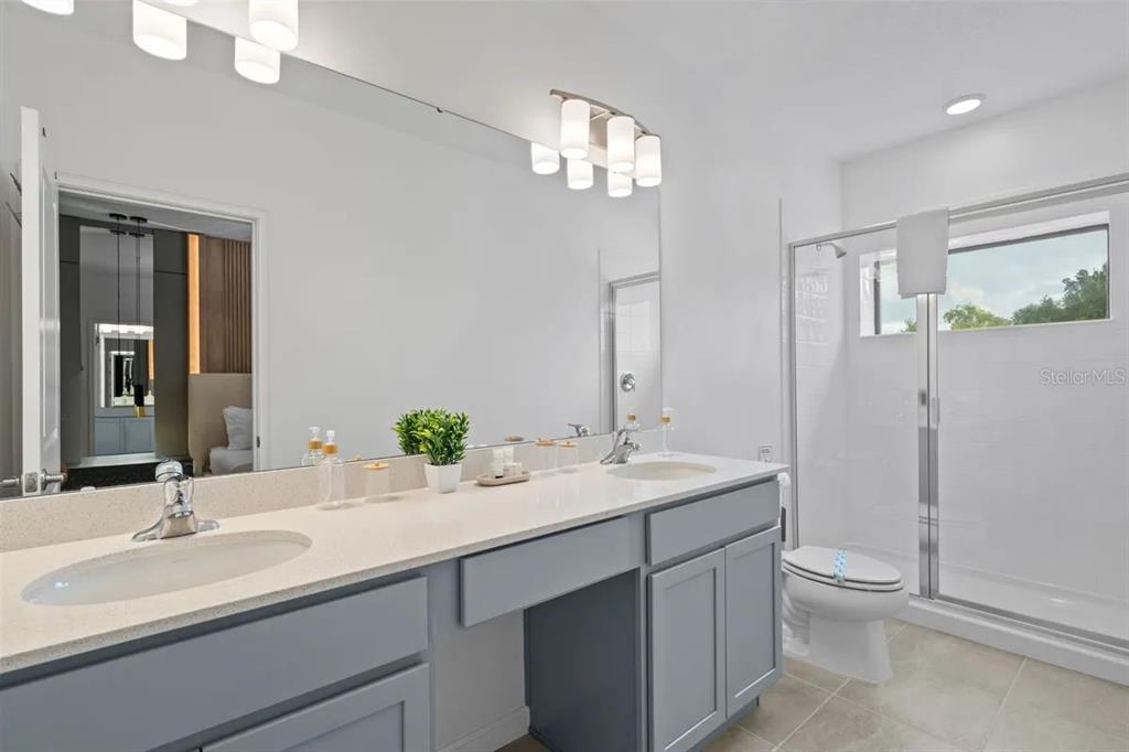 10317 Ebb Tide Lane Orlando, FL 32821 - Photo 30 of 47 a bathroom with a double vanity sink toilet and shower