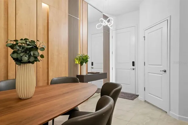 a dining room with furniture and a potted plant