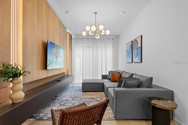 a living room with furniture and a chandelier