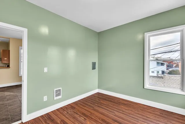 a view of a room with wooden floor and window