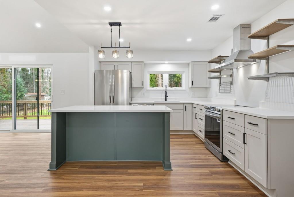3668 Big Springs Road Decatur, GA 30034 - Photo 10 of 45 a kitchen with stainless steel appliances granite countertop a stove top oven a sink dishwasher a refrigerator and a dining table with wooden floor