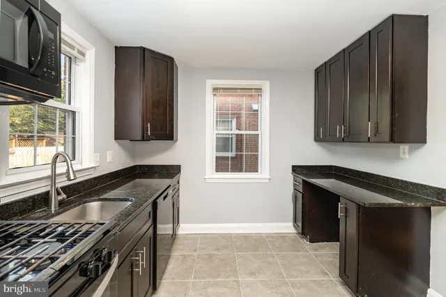 a kitchen with granite countertop a stove and a sink