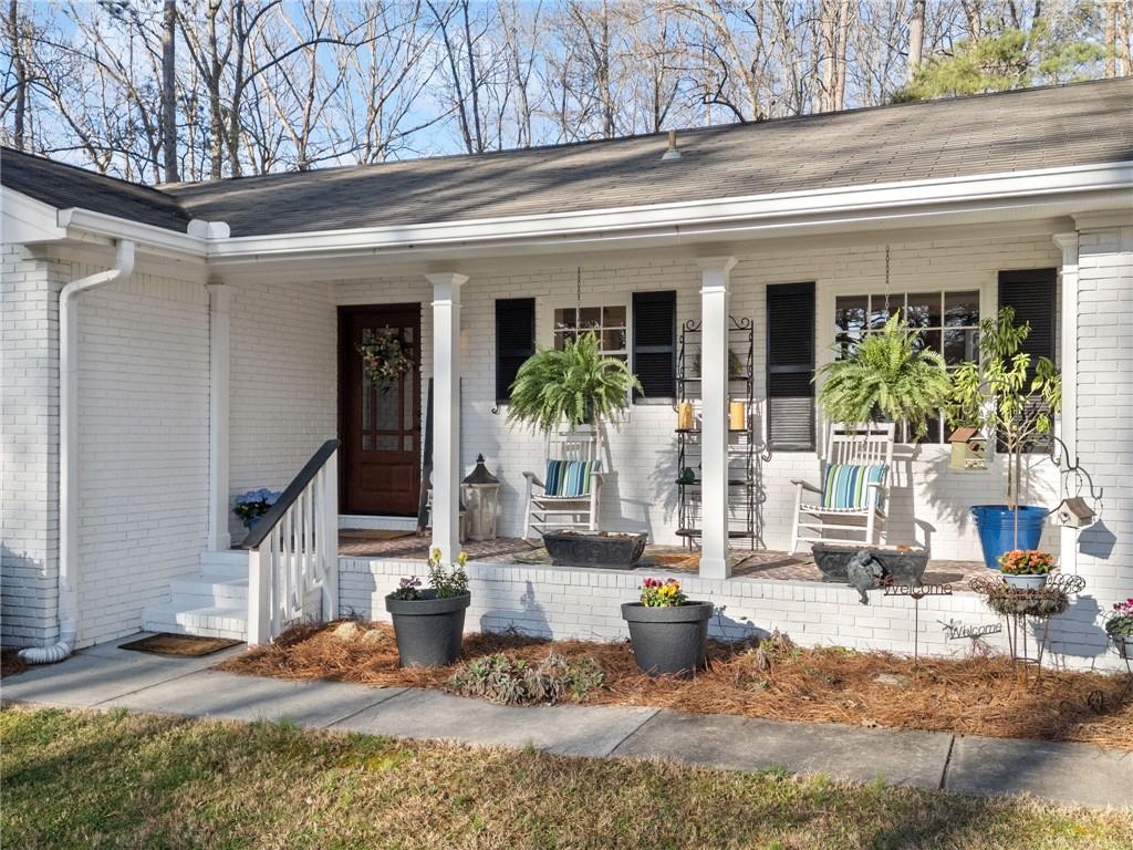 1405 Roper Road Canton, GA 30115 - Photo 1 of 1 a view of a building with potted plants and couches chairs