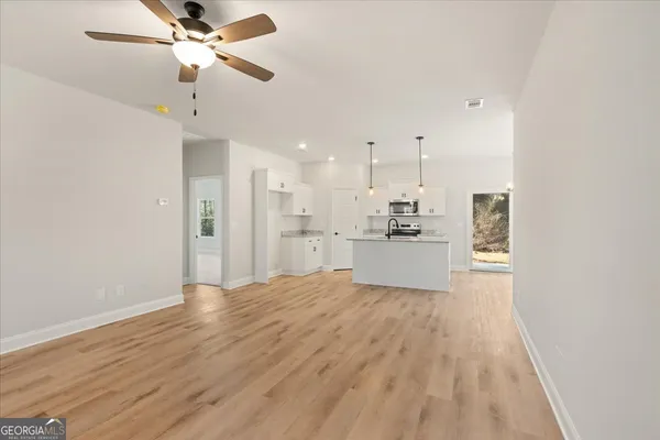 a view of a kitchen with a sink and dishwasher a refrigerator with wooden floor