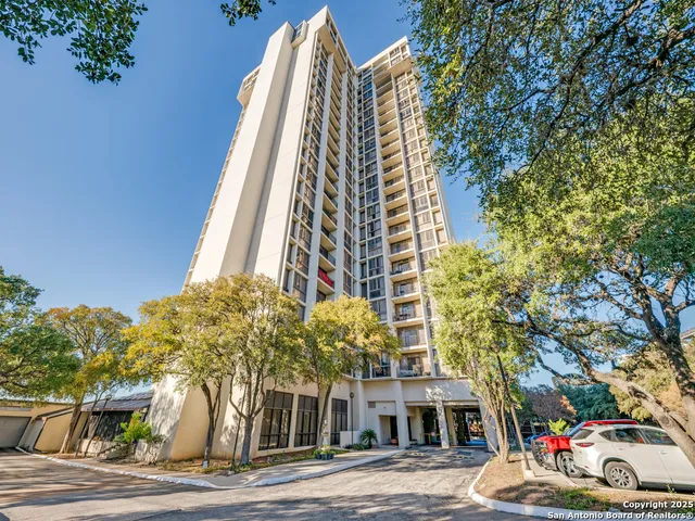 a view of a tall building next to a road