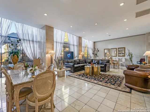 a living room with lots of furniture and a floor to ceiling window