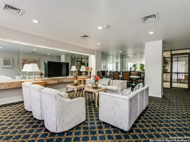 a living room with kitchen island a flat screen tv and a table