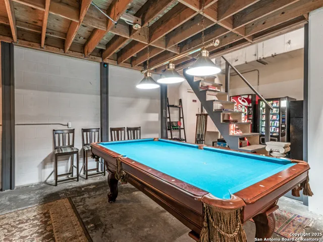 a room with pool table and windows