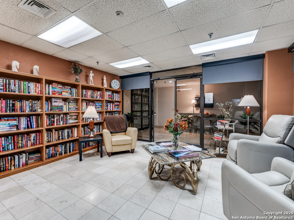 7701 Wurzbach Road, Unit 806 San Antonio, TX 78229 - Photo 10 of 20 a living room with furniture and a book shelf