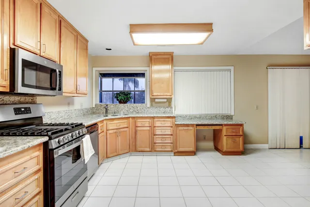 a kitchen with stainless steel appliances granite countertop a stove a sink and a microwave