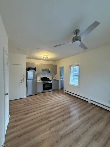 a view of a kitchen with a sink cabinets and a ceiling fan