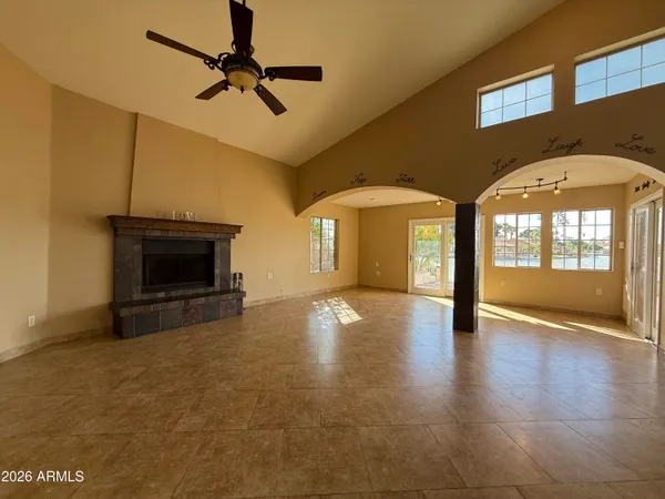 a view of an empty room with a fireplace and a window