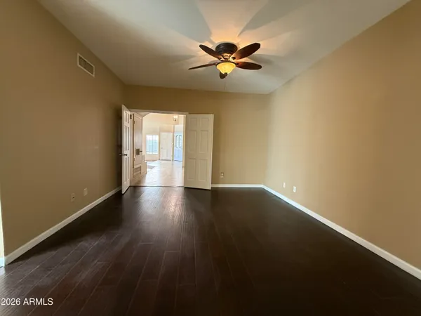 a view of wooden floor and a chandelier fan in a room