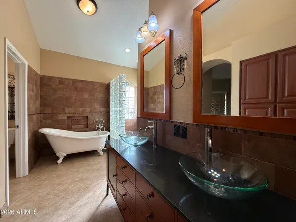 a living room with large couches chandelier and a large mirror with wooden floor