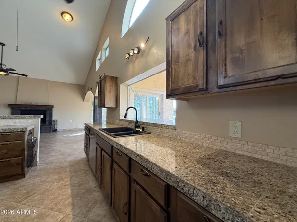 a kitchen with granite countertop a sink and a stove