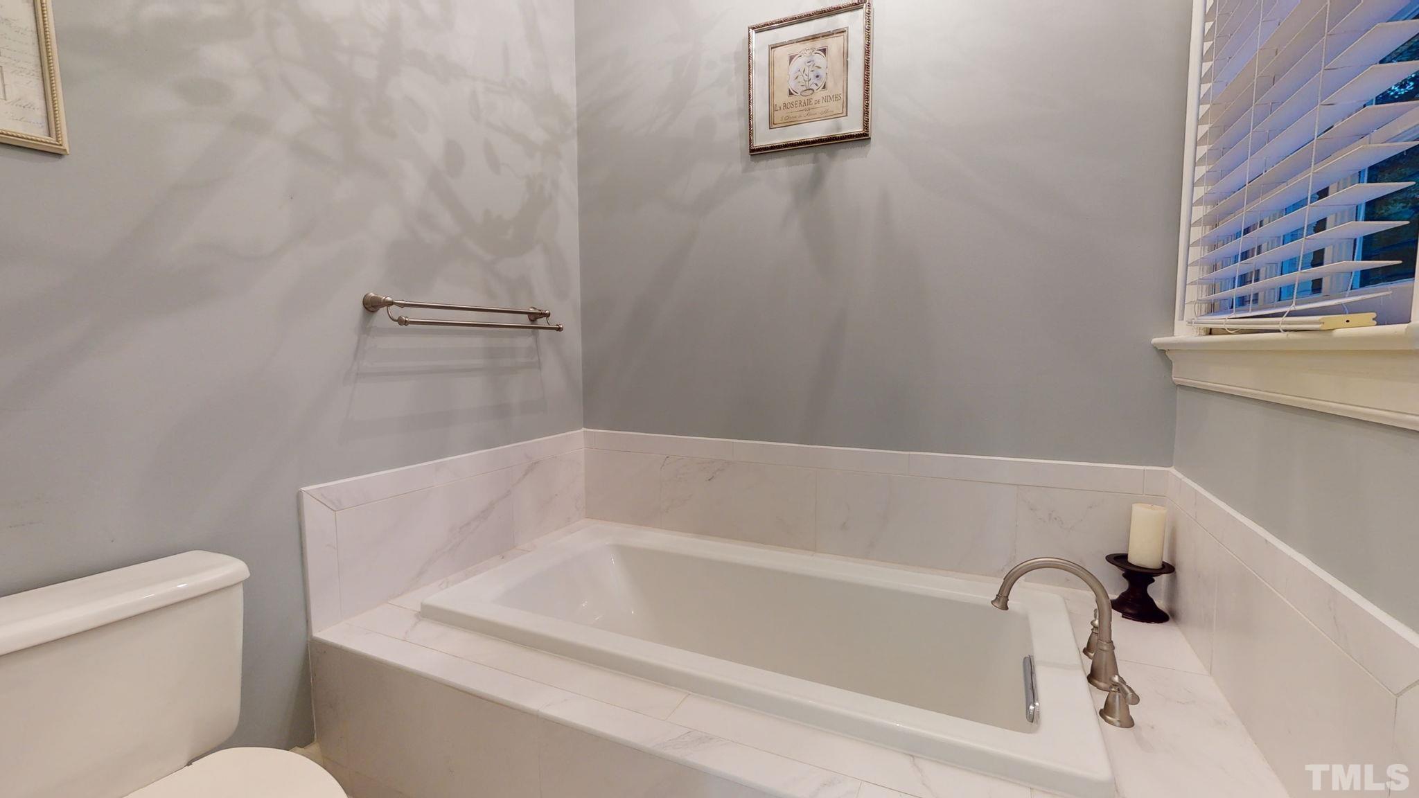 7313 Rainwater Road Raleigh, NC 27615 - Photo 20 of 30 a white bath tub sitting next to a white toilet