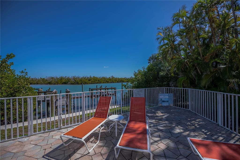 2255 North Beach Road, Unit 20 Englewood, FL 34223 - Photo 15 of 50 a view of deck with two chairs and wooden fence